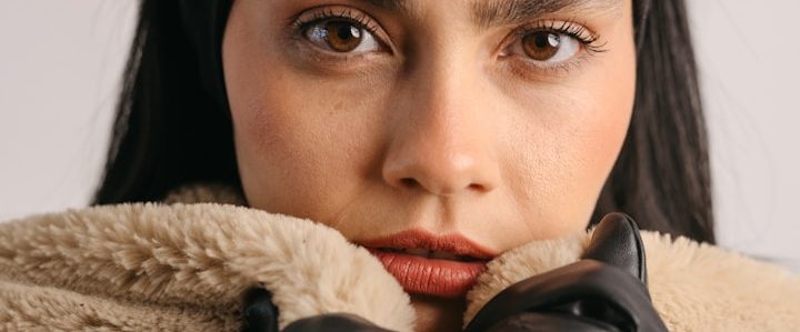 Nahaufnahme eines nachdenklichen Gesichts einer Frau mit dunklen Haaren.