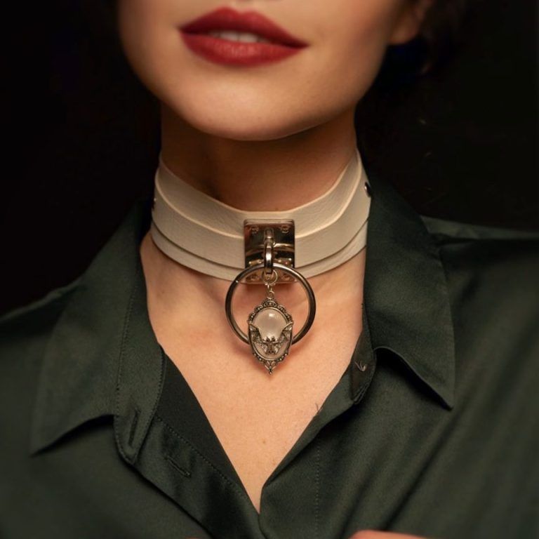 Schmuckstück: Elegantes weißes Choker-Halsband mit Anhänger und schwarzem Oberteil.