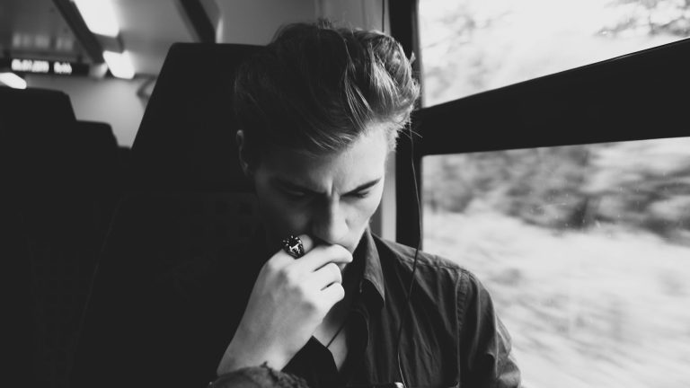 Person trägt eine leuchtende Maske und zeigt mit einer Hand nach vorne.